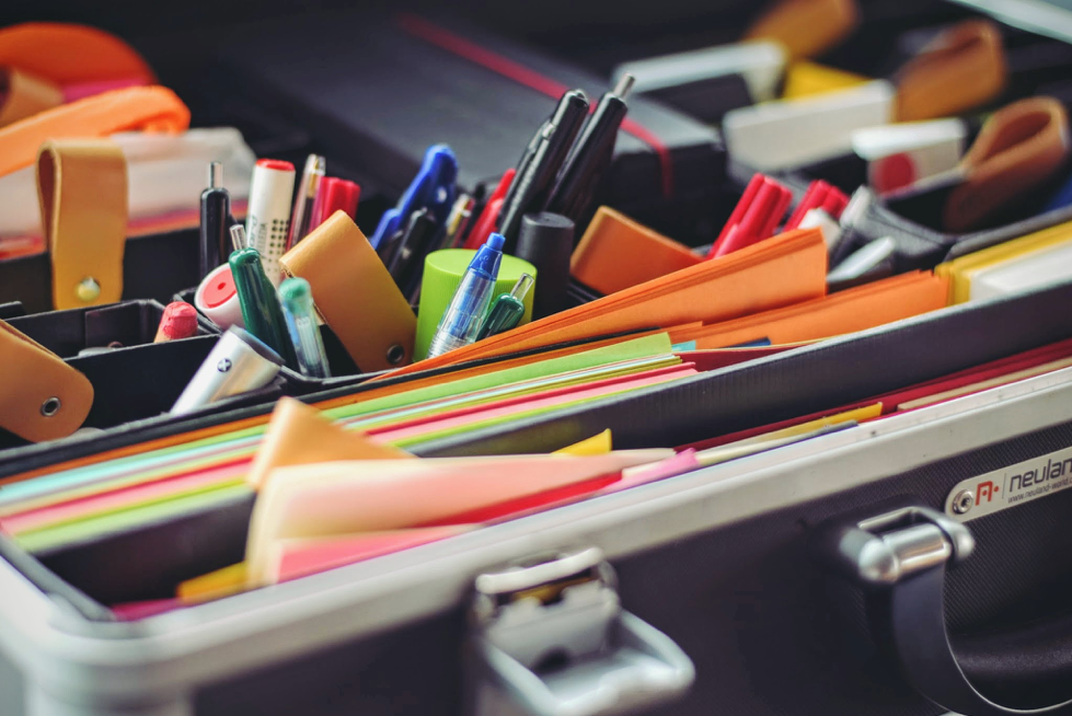 Box of stationery with pens and paper