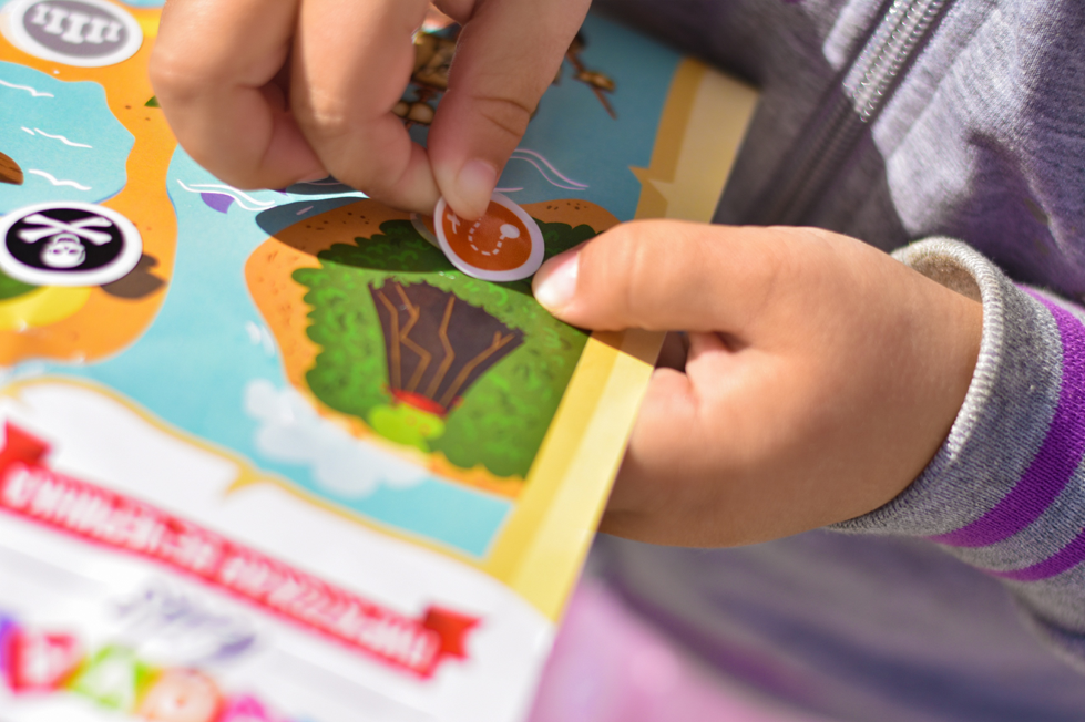 Child placing sticker on map